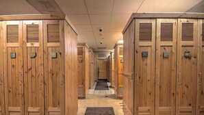 A row of wooden lockers with numbers on them, leading to a door at the end. - Heart of River Run Village! (Keystone)