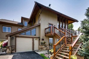 A two-story house with a garage, a wooden staircase, and a small porch area. - Epic Lake and Mountain Views! (Dillon)