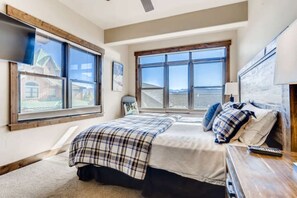 A bedroom with a bed, a desk, and a window with a view. - Amazing Heart of Frisco Condo (Frisco)