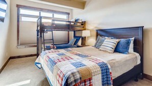 A bedroom with a bunk bed, a large window, and a ceiling fan. - Amazing Heart of Frisco Condo (Frisco)