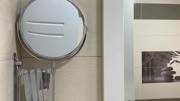 Une salle de bain équipée de toilettes, d’un porte-serviettes et d’un miroir.