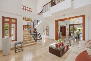 A spacious living area with a staircase, a dining area, and a view of the outdoors. - Villa Bella Laguna | Beach Access (Sosúa)