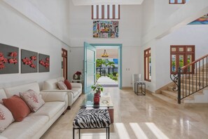 A spacious living area with a sofa, a coffee table, and a zebra-patterned ottoman. - Villa Bella Laguna | Beach Access (Sosúa)