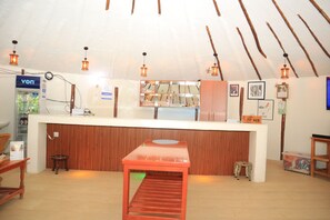 A reception area with a wooden counter, a refrigerator, and a 'Tip Box' sign.