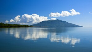 Ein stiller See mit einem Berg im Hintergrund und wolkenlosem Himmel.