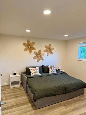 Un dormitorio con cama, mesitas de noche y decoración en la pared.