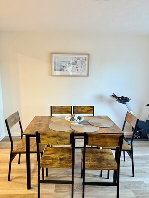 A dining area with a wooden table, four chairs, and a framed artwork on the wall. - Modern 3BR Townhouse Close To Downtown Pittsburgh (Pittsburgh)