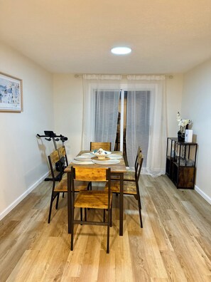A dining area with a wooden table, chairs, and a ceiling light. - Modern 3BR Townhouse Close To Downtown Pittsburgh (Pittsburgh)