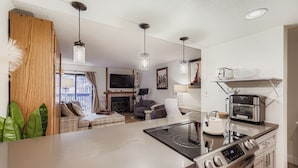Een moderne keuken met een keukeneiland, een ingebouwde oven en een zithoek met een bank en tafel.