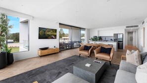 Ein modernes Wohnzimmer mit einer Couch, einem Couchtisch und einem Essbereich mit Stühlen.