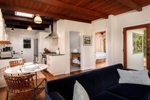 Ein gemütliches Interieur mit Essbereich, Küche und Wohnzimmer mit Sofa und Kissen.