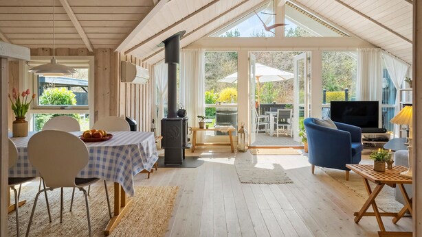 Een gezellige kamer met een eettafel, stoelen, een televisie en een open haard.