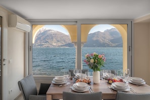 A dining table set for four with a view of a lake and mountains. - Dolce Riva - Three Bedroom Villa, Sleeps 8 (Acquaseria)