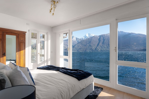 A bedroom with a large window, a bed, and a view of a mountain and water. - Dolce Riva - Three Bedroom Villa, Sleeps 8 (Acquaseria)