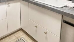 A kitchen with a white sink, stainless steel cabinets, a window, and a potted plant. - Chic 2BR Mount Pleasant Suite Near Downtown (Vancouver)