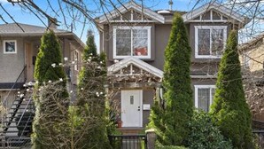 A two-story house with a front porch, a staircase, and a small garden with tall trees. - Chic 2BR Mount Pleasant Suite Near Downtown (Vancouver)