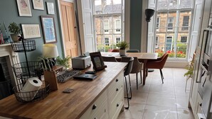 A modern kitchen with a wooden countertop, a toaster, a laptop, and a coffee machine. - Luxurious apartment in the New Town. Walking distance from central Edinburgh (Edinburgh)