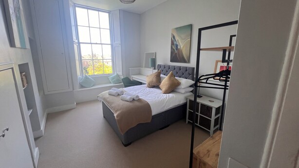 A bedroom with a bed, bedside tables, a window, and a hanging light fixture. - Luxurious apartment in the New Town. Walking distance from central Edinburgh (Edinburgh)