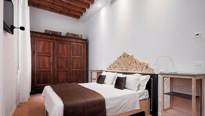 A bedroom with a wooden bed, a wardrobe, and a bedside table. - Stradivari apartment in Venice historic center (Venezia)