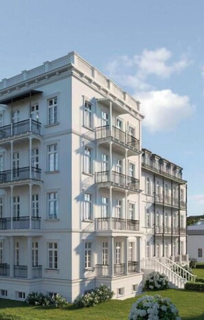 A multi-story building with balconies, a staircase, and a well-maintained lawn. - Luxury apartment with rooftop terrace (Bad Doberan-Heiligendamm)