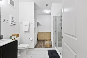 A modern bathroom with a toilet, sink, and shower area. - 5 mins to Broadway. Downtown. Midtown. Pool. Gym (Nashville)