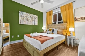 A bedroom with a bed, a headboard, a nightstand, a mirror, and a window with curtains. - 5 mins to Broadway. Downtown. Midtown. Pool. Gym (Nashville)