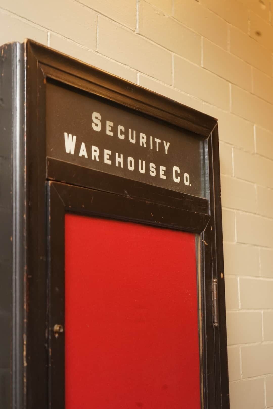 Un panneau indiquant un entrepôt de sécurité, avec une porte rouge.