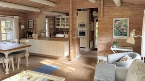 Interior acogedor de una cabaña con comedor, cocina y sala de estar.