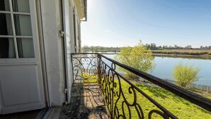 Un balcon donnant sur une rivière et des arbres.