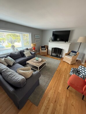 A living room with a sofa, coffee table, and a fireplace. - Family-Friendly 5BR Normandy Beach Home with Plenty of Outdoor Space (Lavallette)