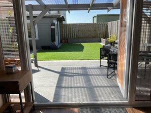 A patio with a concrete floor, a wooden table, and a black chair. - Lakeland Lettings in the heart of Barrow with view of the Reservoir (Barrow-in-Furness)