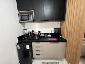 A compact kitchen with a microwave, coffee maker, and small refrigerator. - Sun 112 · Fantastic beachfront apartment in Intermares (Cabedelo)