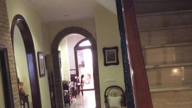 A polished hallway with a wooden staircase, a brick wall, and a door leading to another room. - Paquita's House (Priego de Córdoba)