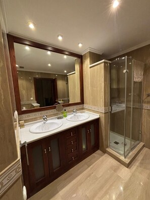 A bathroom with two sinks, a large mirror, and a glass-enclosed shower. - Paquita's House (Priego de Córdoba)
