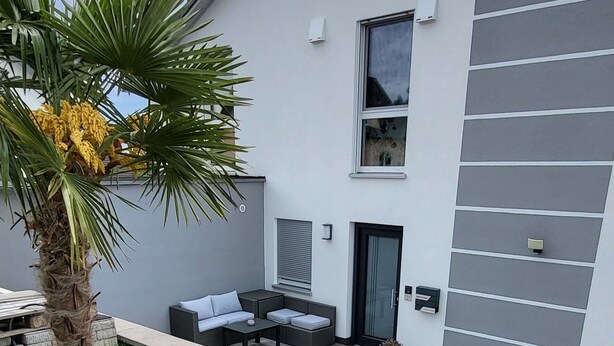 Un edificio moderno con techo plano, una ventana pequeña y una puerta.