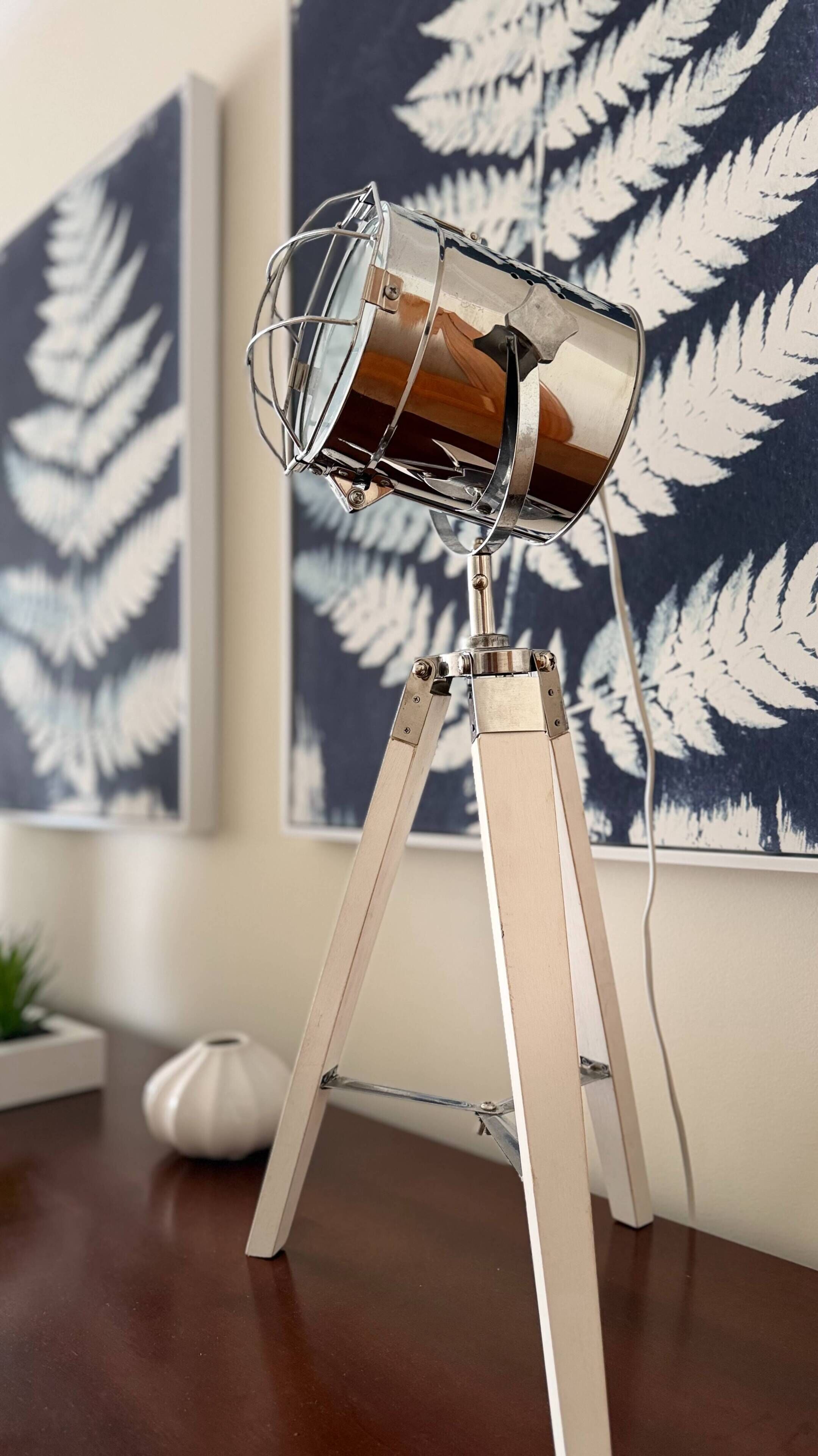 Un objet métallique à surface réfléchissante, peut-être un élément décoratif, posé sur un trépied.