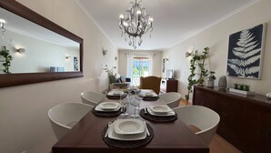 A dining area with a table set for four, a chandelier, and a large mirror on the wall. - Old Town Albufeira Retreat (Albufeira)