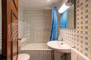 A bathroom with a bathtub, a sink, and a mirror. - Baía Seaview | 2-Bedroom Apartment (Funchal)