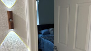 Ein Schlafzimmer mit Bett, Tür und Fenster.