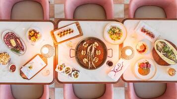 Una mesa de comedor con varios platos, incluyendo un tazón de arroz, una porción de sushi y un bol de sopa.