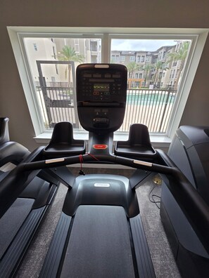 A treadmill with a digital display, a stop button, and a red cord. - Modern Escape Near Waterpark (Houston)