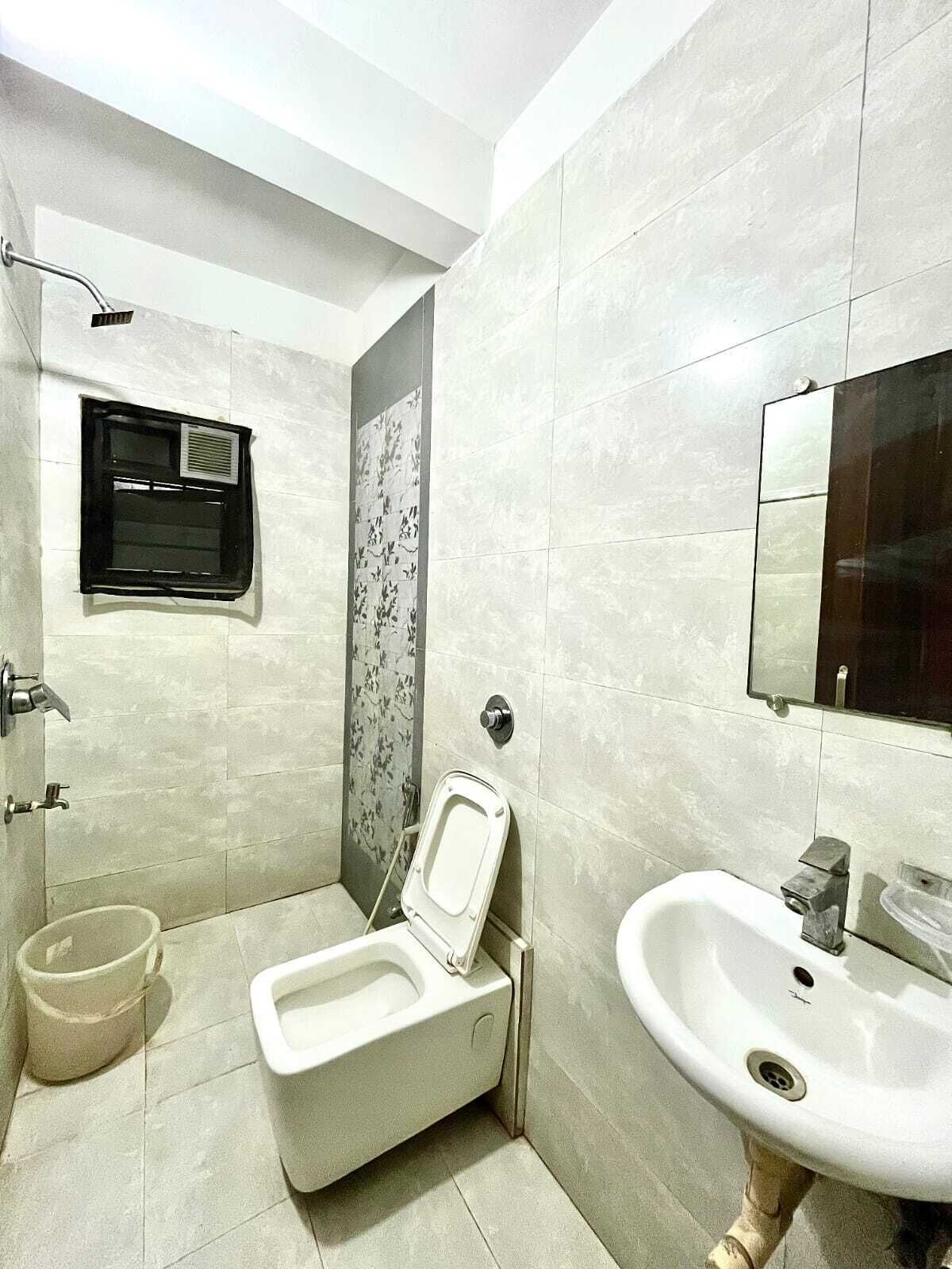 A modern bathroom with a toilet, sink, and shower.