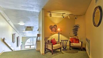 A hallway with two armchairs, a lamp, and a mirror on the wall.