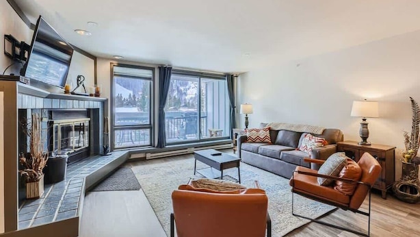 A modern living room with a fireplace, a sofa, a chair, and a television. - Near Lifts, Ski Keystone, Sleeps up to 6 People (Keystone)