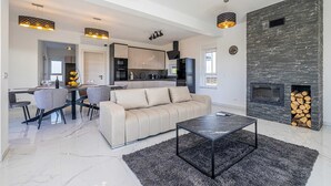 Ein modernes Wohnzimmer mit Sofa, Couchtisch und Essbereich.