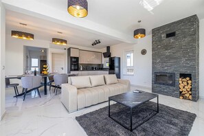 A modern living room with a sofa, coffee table, and dining area. - Holiday house VILLA PATRICK with pool, jacuzzi and sauna (Kornić)