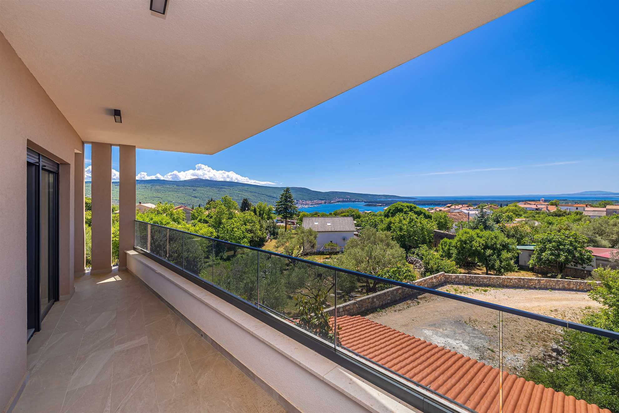Un balcon offrant une vue dégagée sur un paysage côtier, comprenant une montagne et la mer.