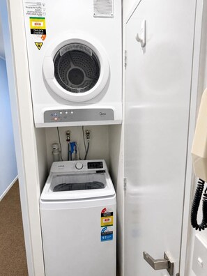 Eine kompakte Waschtrockner-Kombination mit Frontlader, ENERGY STAR-Kennzeichnung und Aufkleber zur Kennzeichnung der Wassereffizienz.