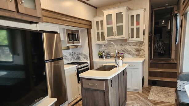 Una cocina compacta equipada con refrigerador, microondas, estufa y pileta.