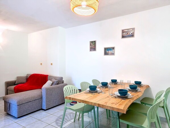 A dining area with a wooden table, green chairs, and blue bowls. - Noulakaz - Balcon - Montagne (Saint-Denis)